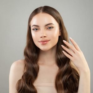 Perfect woman with long healthy hair, clear skin and hand with manicured nails. Skin care and hair care concept